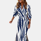 Front view of the Freya Summer Midi Dress Striped Wrap in blue, featuring a collared neckline, long sleeves, wrap-style waist, and an elegant striped midi silhouette. Designed by Bella Hudson.