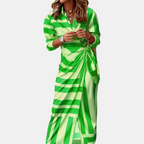 Front view of the Freya Summer Midi Dress Striped Wrap in green, featuring a collared neckline, long sleeves, wrap waist tie, and bold striped pattern. Designed by Bella Hudson.