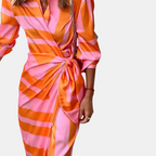 Detail of the Freya Summer Midi Dress Striped Wrap in orange, featuring the wrap waist tie, collared neckline, button-front design, and bold striped print. Designed by Bella Hudson.