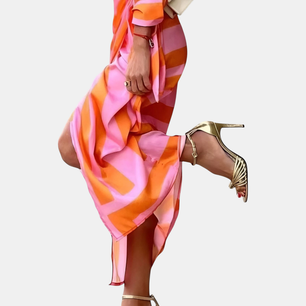Lower side detail view of the Freya Summer Midi Dress Striped Wrap in orange, showcasing the tied wrap waist, striped pattern, and flowing midi-length design. Designed by Bella Hudson.