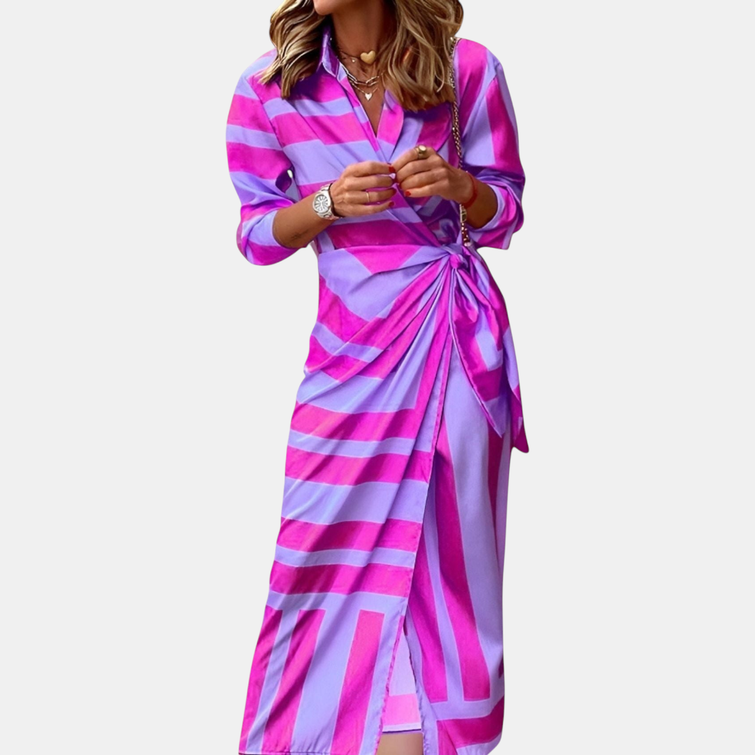 Front view of the Freya Summer Midi Dress Striped Wrap in purple, showcasing a collared neckline, long sleeves, wrap-style waist tie, and a bold striped midi-length silhouette. Designed by Bella Hudson.