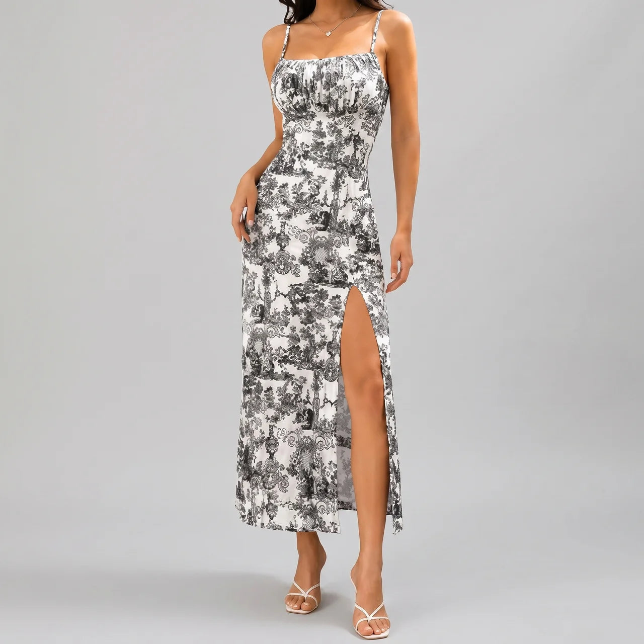 Front view of gray floral slit maxi dress with spaghetti straps and fitted silhouette by BELLA HUDSON