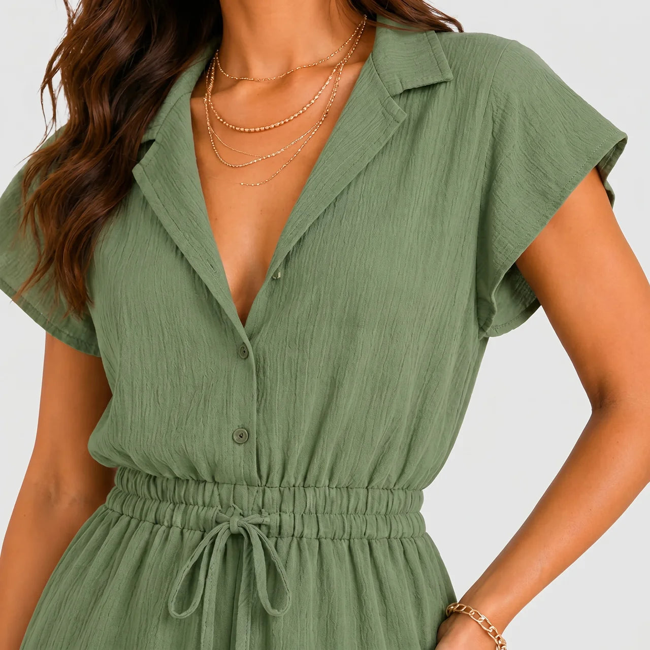 Close-up view of green tiered romper with drawstring waist and cap sleeves by BELLA HUDSON