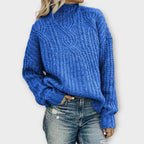 Front view of the Halvard Sweater Cable-Knit Turtleneck in blue, featuring a high turtleneck, textured cable-knit pattern, long sleeves, and a relaxed cozy silhouette. Designed by Bella Hudson.