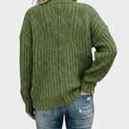 Back view of the Halvard Sweater Cable-Knit Turtleneck in green, highlighting the textured knit construction, high turtleneck, long sleeves, and relaxed silhouette. Designed by Bella Hudson.