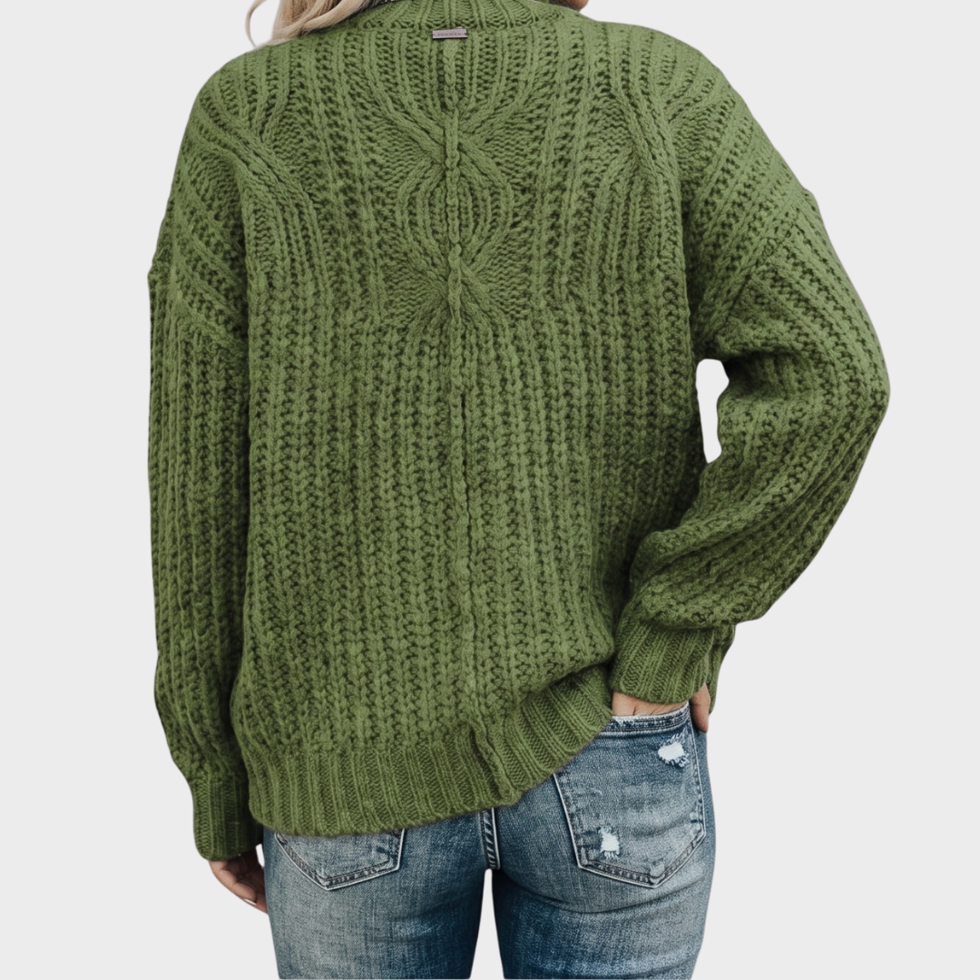Back view of the Halvard Sweater Cable-Knit Turtleneck in green, highlighting the textured knit construction, high turtleneck, long sleeves, and relaxed silhouette. Designed by Bella Hudson.