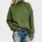 Front view of the Halvard Sweater Cable-Knit Turtleneck in green, featuring a high turtleneck, textured cable-knit pattern, long sleeves, and a relaxed cozy silhouette. Designed by Bella Hudson.
