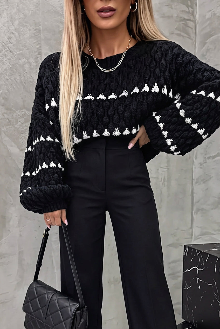 Harper Black chunky knit sweater with white stripes and balloon sleeves, styled with black trousers.