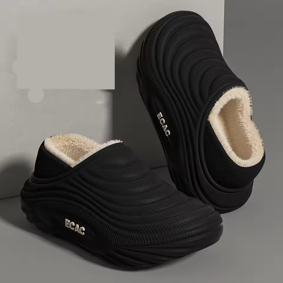 Isla Black slip-on clog slippers featuring a textured ribbed upper, plush interior lining, and thick sculpted sole