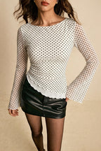 Isla White Small Dot mesh top styled with a black mini skirt, showing the fitted body and sheer bell sleeves.
