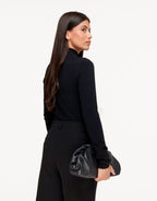 Isolde Black turtleneck sweater shown from the back and side, highlighting the fitted long sleeves and high neck.