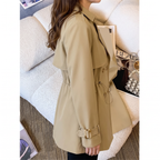 Back model view of the Jennifer Trench Coat Belted Double-Breasted in khaki, showcasing the fitted waist, long sleeves with buckle cuffs, structured back, and gently flared hem. Designed by Bella Hudson.