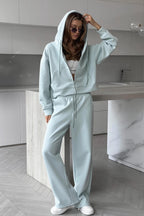 Jolene Blue zip-up hoodie with hood up and wide-leg drawstring sweatpants.