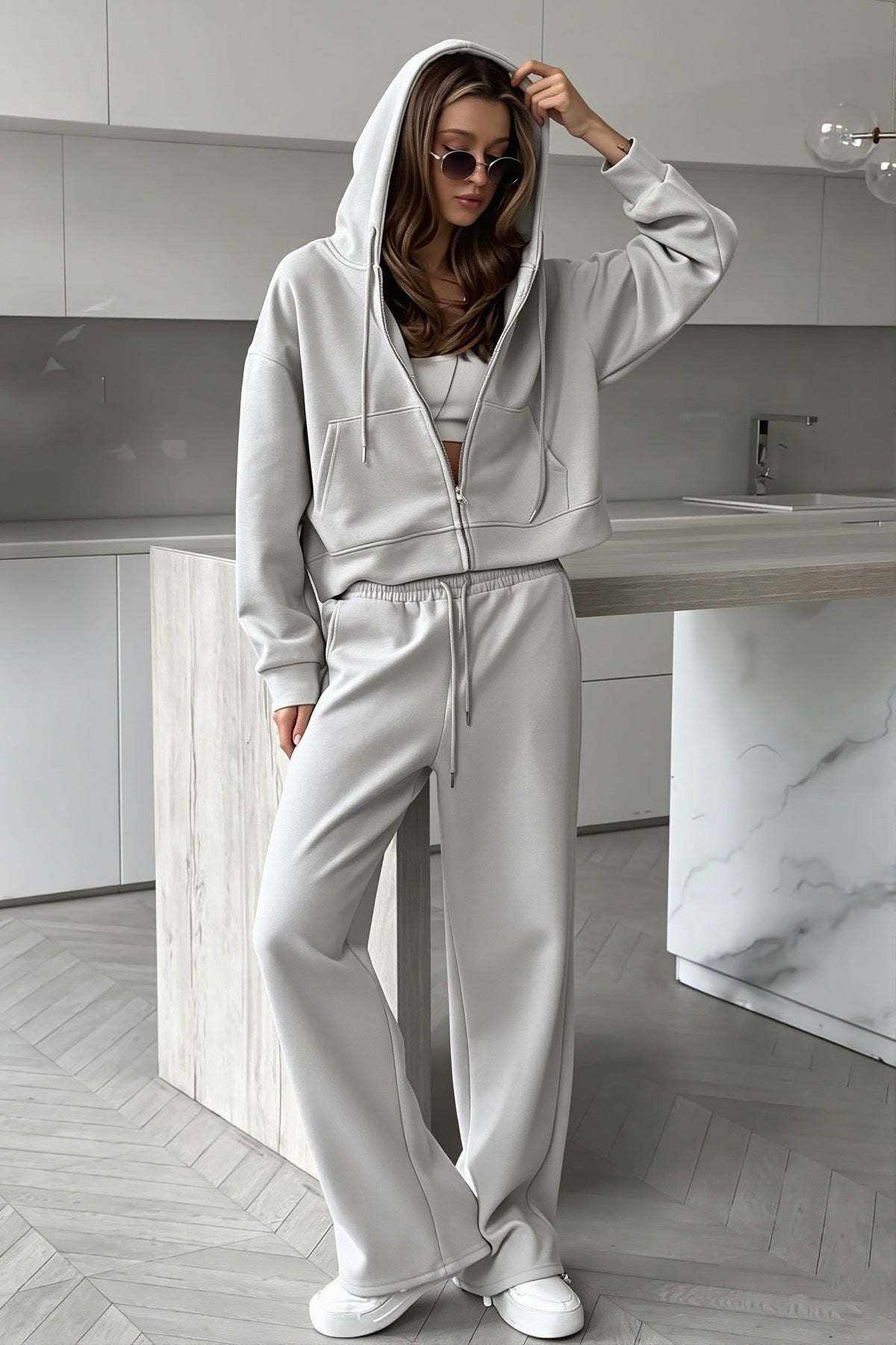 Jolene Gray zip-up hoodie with hood up and wide-leg sweatpants in a kitchen setting.