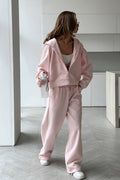Jolene Pink zip-up hoodie and wide-leg sweatpants set styled full-body with white sneakers.