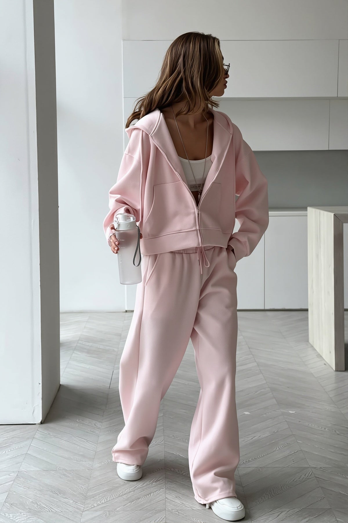 Jolene Pink zip-up hoodie and wide-leg sweatpants set styled full-body with white sneakers.