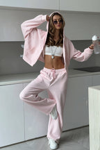 Jolene Pink hoodie worn open over a white crop top with drawstring wide-leg sweatpants.