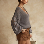 Side view of the Josefine Sweater Lace V-Neck Knit in Grey, showcasing its relaxed fit and long-sleeve design. Designed by Bella Hudson.