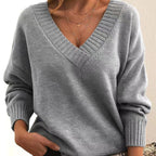 Front view of the Katharina Sweater Knit V-Neck Oversized in gray, featuring a deep V-neckline, long sleeves, ribbed cuffs, soft knit texture, and a relaxed oversized silhouette. Designed by Bella Hudson.