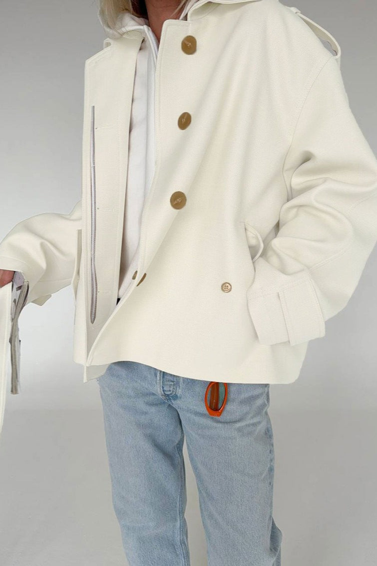 Lena White faux suede short jacket styled from the front with a self-tie waist, lapel collar, and long sleeves