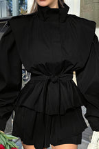 Leona Black belted peplum jacket close up of the stand collar, structured shoulders, belt knot and flared peplum.