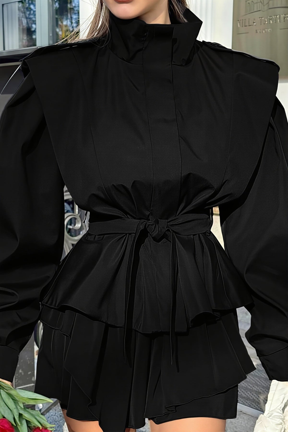 Leona Black belted peplum jacket close up of the stand collar, structured shoulders, belt knot and flared peplum.