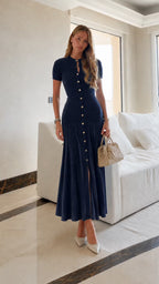 Leonie Dark Blue button-front knit maxi dress styled full-body with a beige handbag.