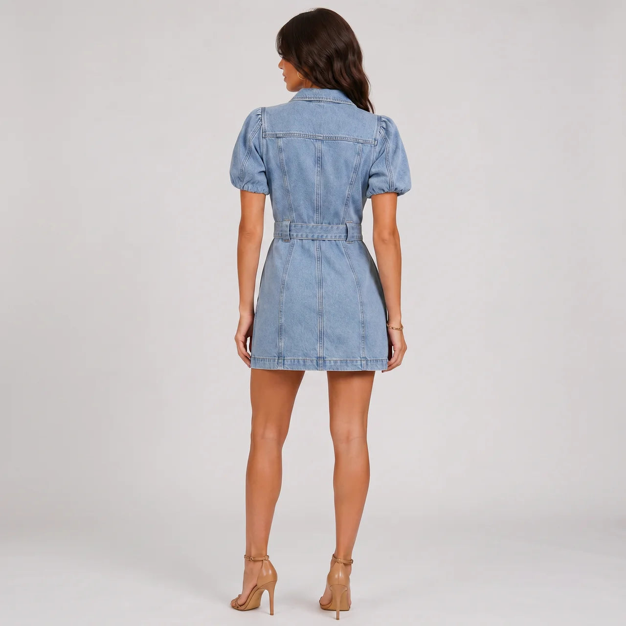 Back view of light wash denim mini dress with puff sleeves and waist belt by BELLA HUDSON