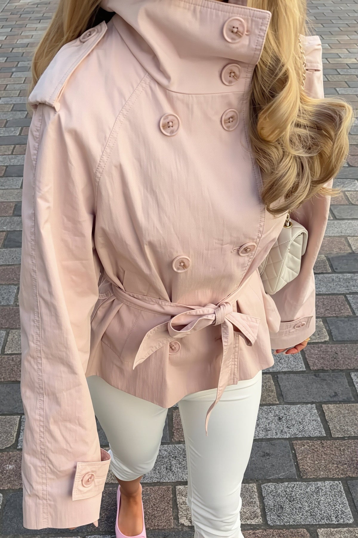 Lila Pink jacket close-up showing the double-breasted buttons, shoulder epaulettes, button-tab cuffs and tied waist belt.
