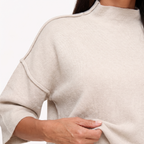 Linnea Taupe close-up of the high neckline, exposed shoulder seam and knit texture.