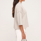 Linnea Taupe high neck knit top shown from the side, highlighting the seam detailing and boxy shape.
