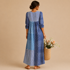 Back view of the Liv Lightweight Polka-Dot Everyday Maxi Dress in blue featuring a patchwork polka-dot design, long sleeves, and a relaxed maxi-length silhouette. Designed by Bella Hudson.