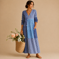 Full-length view of the Liv Lightweight Polka-Dot Everyday Maxi Dress in blue featuring a V-neckline, patchwork polka-dot design, long sleeves, practical pockets, and an easy everyday silhouette. Designed by Bella Hudson.