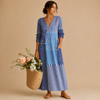 Full-length view of the Liv Lightweight Polka-Dot Everyday Maxi Dress in blue featuring a V-neckline, patchwork polka-dot design, long sleeves, practical pockets, and an easy everyday silhouette. Designed by Bella Hudson.