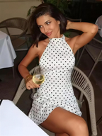 Lucia Chic Polka Dot Mini Dress white halter mini dress with black polka dots and flared skirt for a timeless feminine look.