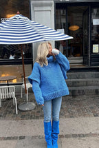 Lydia Blue chunky-knit turtleneck sweater worn with light jeans and blue boots, showing the textured sleeves.