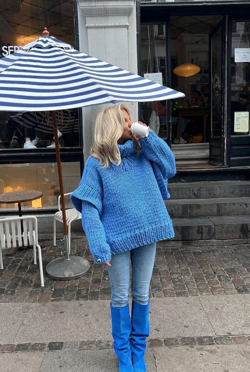 Lydia Blue chunky-knit turtleneck sweater worn with light jeans and blue boots, showing the textured sleeves.