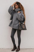 Lydia Gray oversized chunky-knit turtleneck sweater styled with gray leggings, brown ankle boots and a studded shoulder bag.