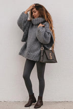Lydia Gray oversized chunky-knit turtleneck sweater styled with gray leggings, brown ankle boots and a studded shoulder bag.