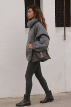 Lydia Gray chunky-knit turtleneck sweater in side view showing the textured sleeve detail and oversized shape.