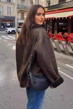 Maeve Brown faux leather jacket shown from the back side with a relaxed mid-length shape, long sleeves, and plush-trim cuffs