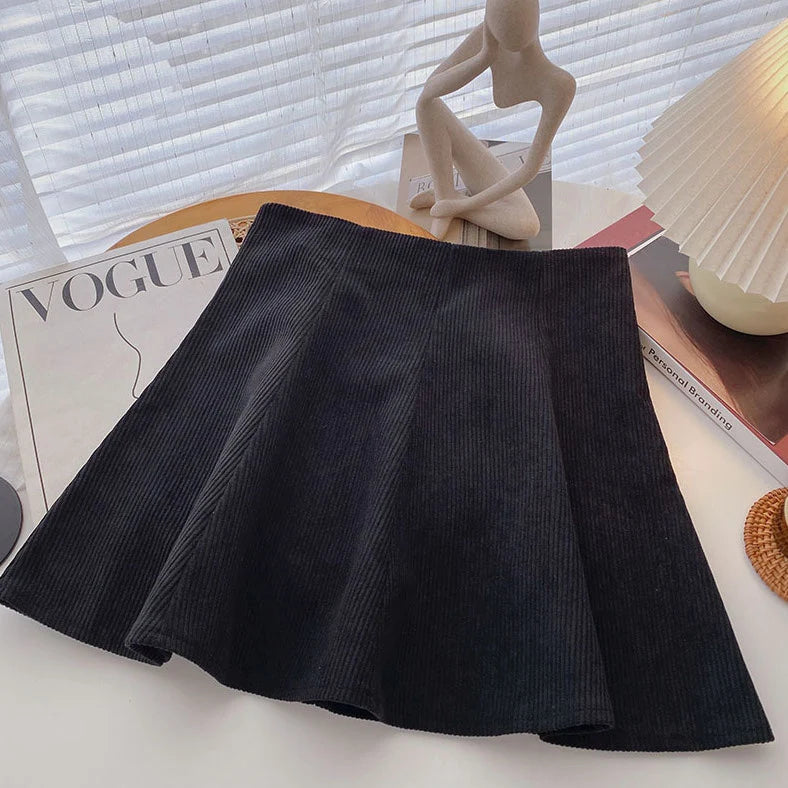 Mara Black high-waist corduroy mini skirt displayed on a hanger