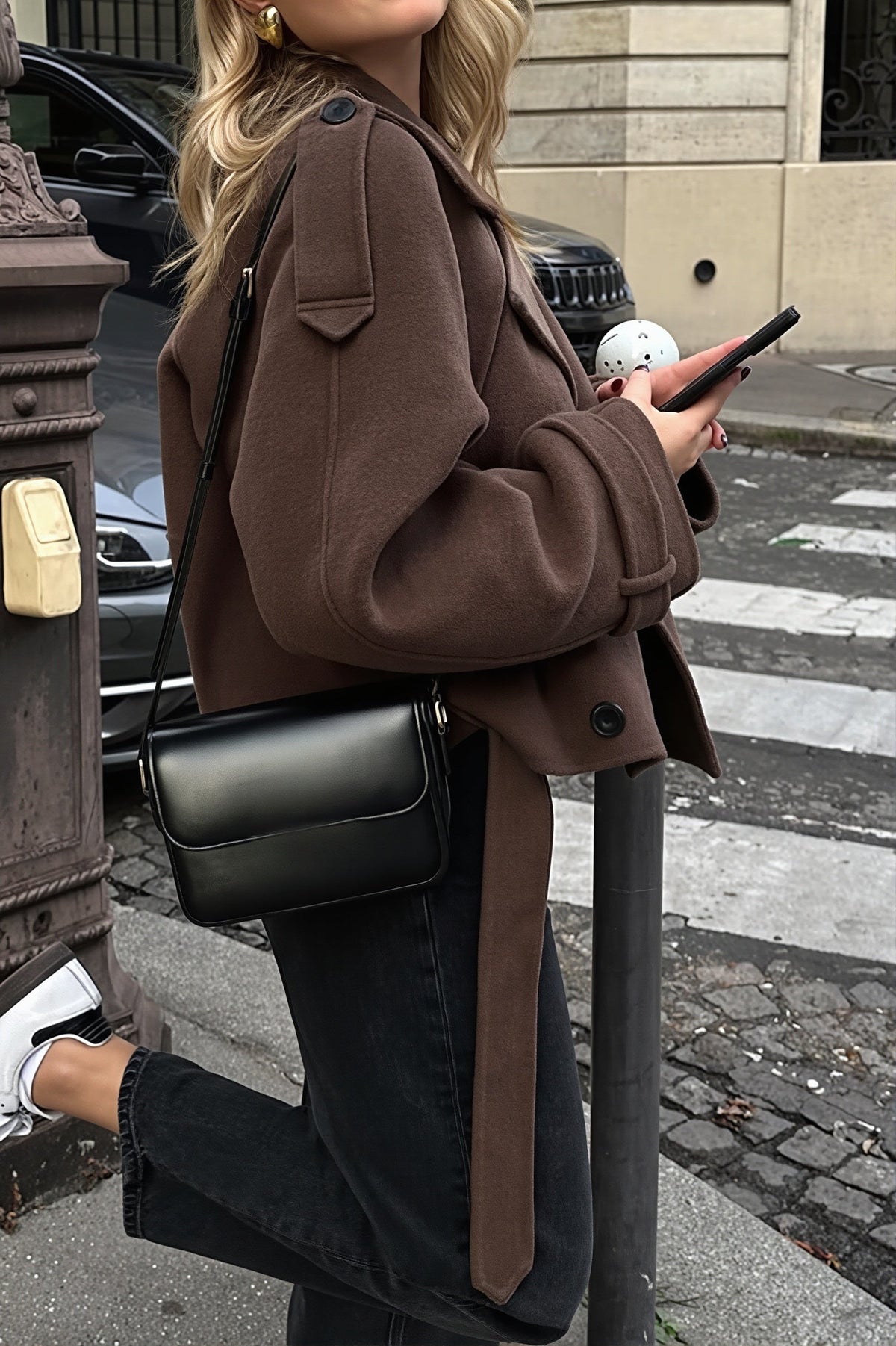 Maren Dark Brown cropped jacket from the side showing shoulder epaulette, long sleeve with cuff tab, and back belt strap.