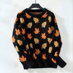 Product view of the Marguerite Sweater Leaf-Print Crew-Neck in black, featuring a crew neckline, long sleeves, orange autumn leaf print, ribbed cuffs and hem, and a relaxed silhouette. Designed by Bella Hudson.
