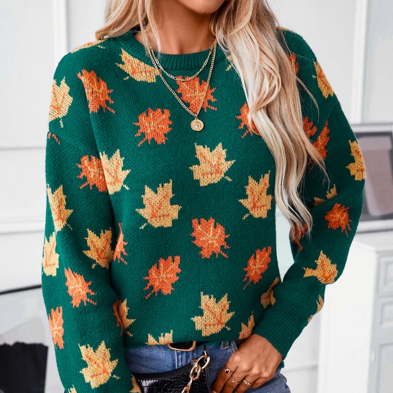 Front view of the Marguerite Sweater Leaf-Print Crew-Neck in green, featuring a crew neckline, long sleeves, orange and yellow autumn leaf print, ribbed cuffs, and a relaxed silhouette. Designed by Bella Hudson.