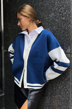 Marielle Dark Blue cardigan in a side view showing white button placket, striped sleeves, and ribbed striped hem.
