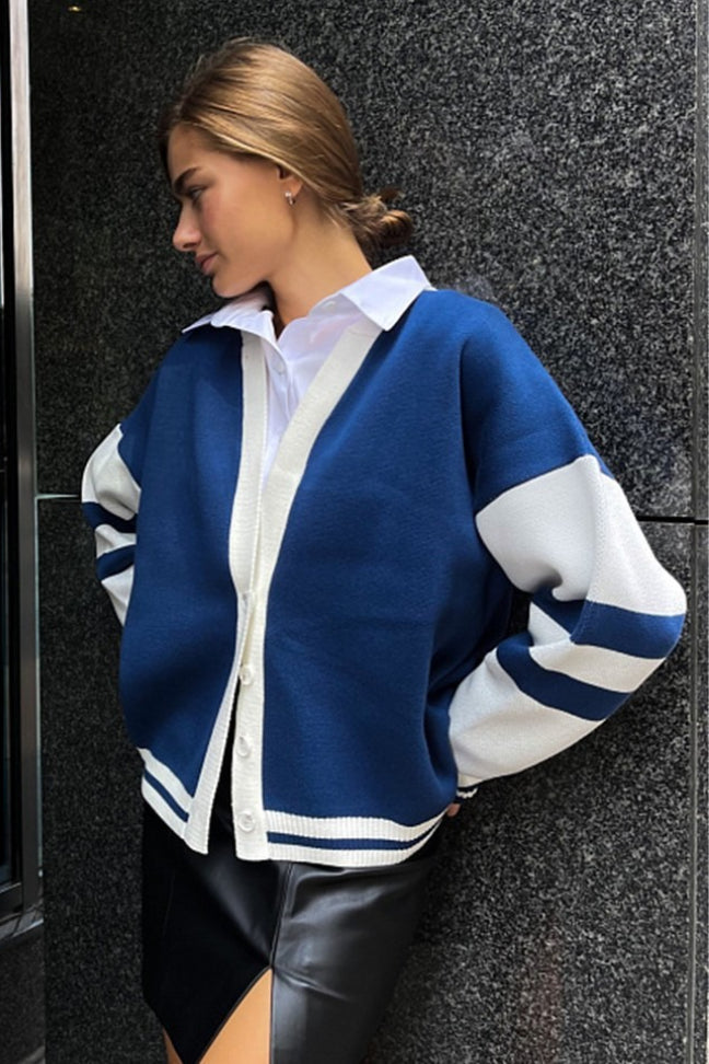 Marielle Dark Blue cardigan in a side view showing white button placket, striped sleeves, and ribbed striped hem.