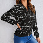 Posing view of the Marisol Jacket Bomber Geometric-Print in black, showcasing the geometric line print, long sleeves, zip-front closure, and relaxed bomber silhouette. Designed by Bella Hudson.