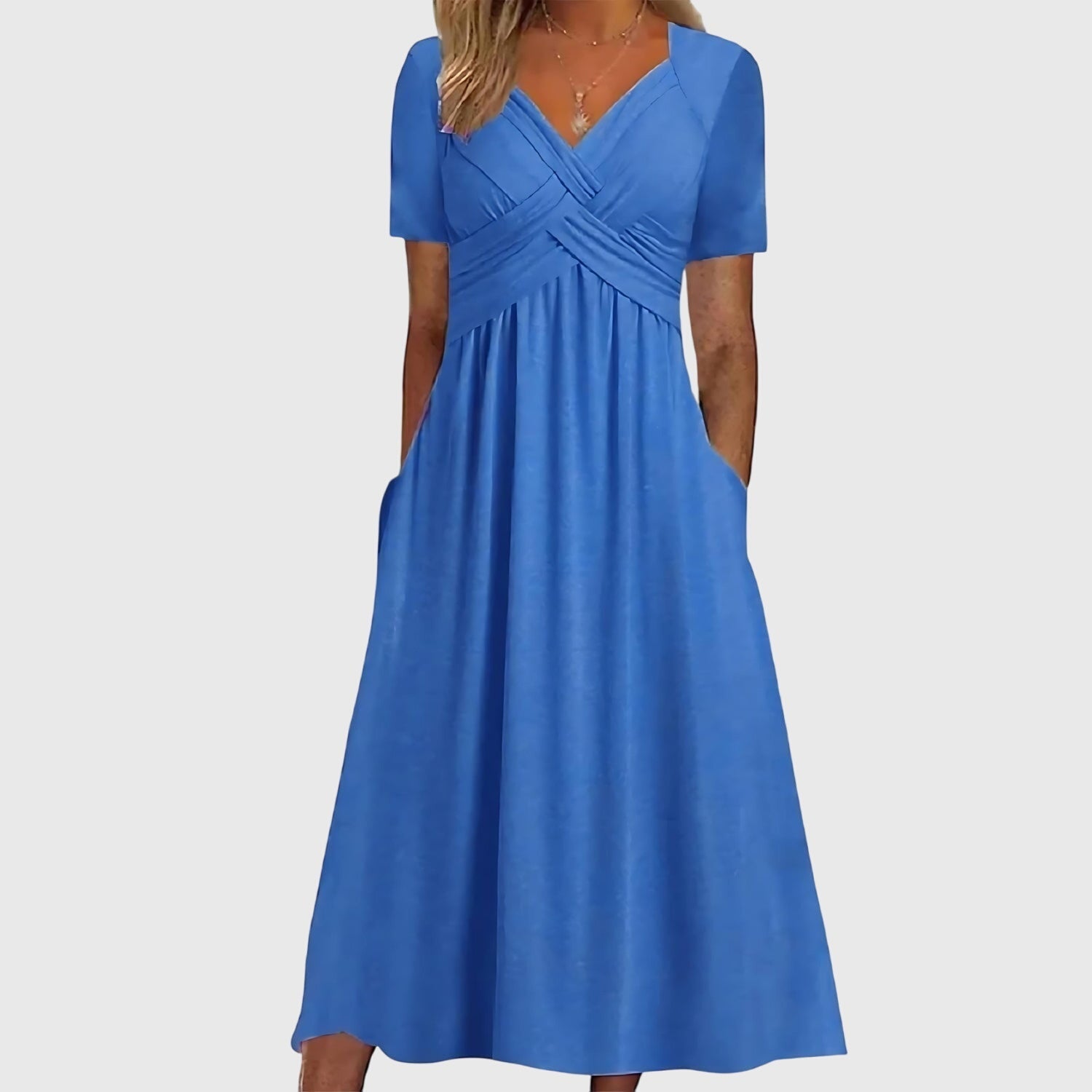 Front view of the Marisol Summer Midi Dress Ruched V-Neck in blue, featuring a flattering V-neckline, ruched crossover bodice, short sleeves, flowing midi skirt, and practical side pockets. Designed by Bella Hudson.