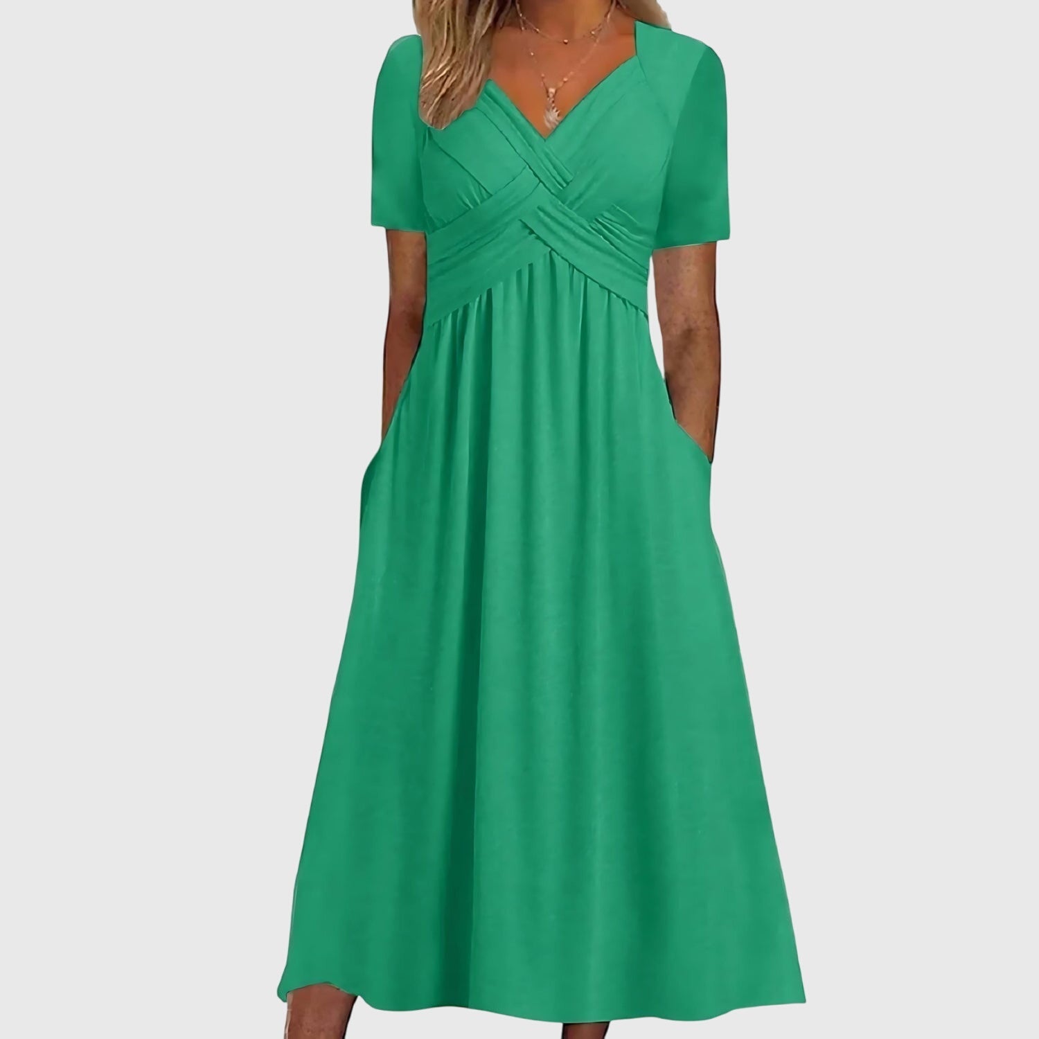 Front view of the Marisol Summer Midi Dress Ruched V-Neck in green, showcasing a ruched crossover bodice, elegant V-neckline, short sleeves, flowing midi skirt, and functional side pockets. Designed by Bella Hudson.